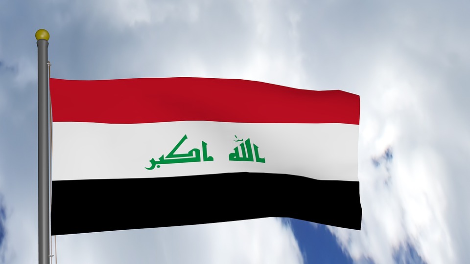 Iraks flagga med färgerna rött, vitt och svart.