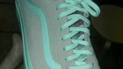 En gympasko med snörning. En del tycker skon är rosa och vit, andra att den är mintgrön och grå.