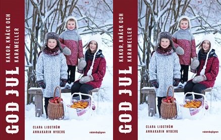 Tre barn poserar ute i snön. Framför sig har de en korg med lussebullar och en korg med äpplen.