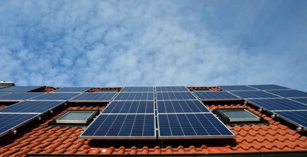 Solceller som satts på en stor platta uppe på ett hustak.