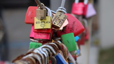 Lås som sitter på en bro med text och hjärtan på dem