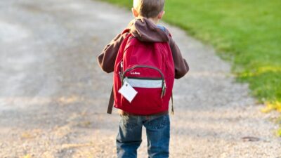 En pojke med en ryggsäck på ryggen.